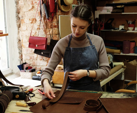 Young Woman Works In A Bag Making Studio, Cuts Out Details