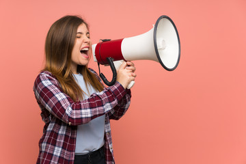 Young girl over pink wall shouting through a megaphone