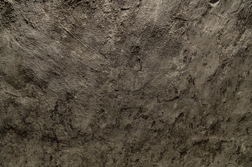 Old worn plastered surface. Dark, dirty, shabby, uneven background. 