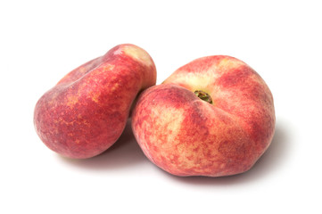 Closeup of organic flat peaches on white background