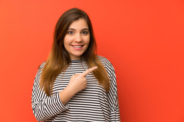 Young girl with striped shirt pointing finger to the side