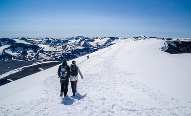 Fototapeta na wymiar People hiking on top of Glittertind - the highest mountain in Jotunheimen, Norway. Galdhøpiggen seen in the horizon.