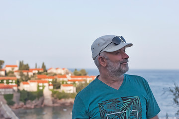 Obraz premium A man of mature age in a baseball cap looks away