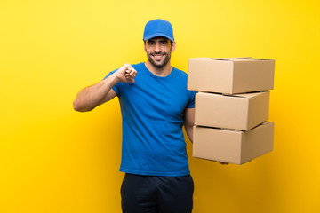 Fototapeta na wymiar Young delivery man over isolated yellow wall proud and self-satisfied