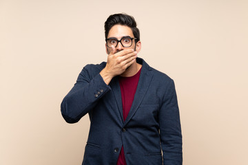 Handsome young man over isolated background covering mouth with hands