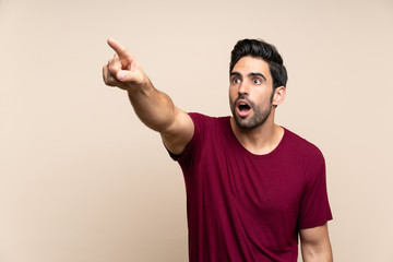 Fototapeta premium Handsome young man over isolated background pointing away