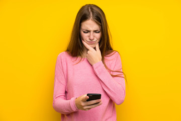 Naklejka premium Young woman with long hair over isolated yellow wall thinking and sending a message