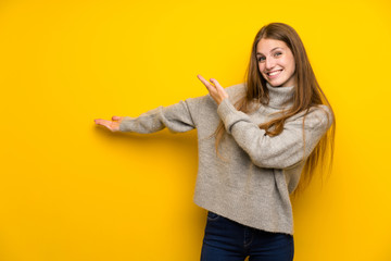 Young woman with long hair over yellow background extending hands to the side for inviting to come