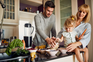 Happy family in kitchen making breakfast