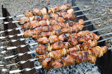 Marinated shashlik preparing on a barbecue grill. Juicy tasty roasted pork meat.
