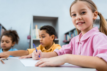 selective focus of happy kid drawing near african american children