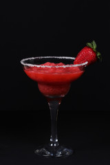 cold strawberry smoothie with ripe strawberries on a black background