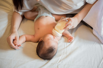 Fototapeta na wymiar Newborn baby girl is drinking milk by her mother