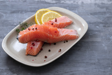 raw salmon with dill on white dish on ceramic background