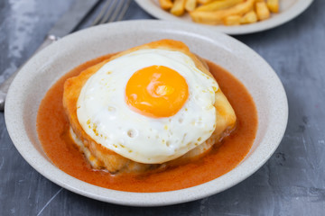 typical portuguese dish francesinha in dish on ceramic background