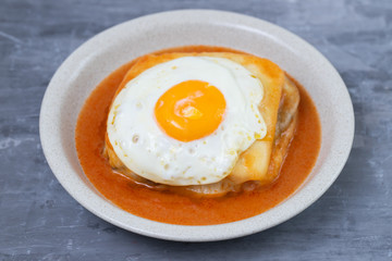 typical portuguese dish francesinha in dish on ceramic background