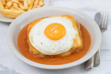 typical portuguese dish francesinha in dish on ceramic background