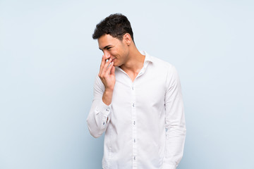 Handsome man over blue wall smiling a lot