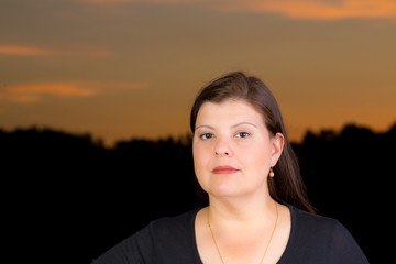 Woman Portrait serious during twilight that is behind her