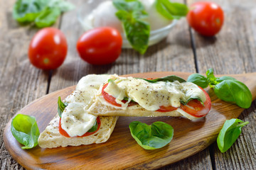 Panini  Caprese: Gebackenes Italienisches Panini mit geschmolzenem Mozzarella, Tomaten und Basilikum – Baked panini with melted buffalo cheese, tomatoes and basil fresh from the oven