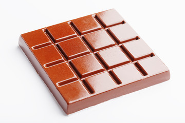 Square-shaped milk chocolate on a white background from above. Isolated A whole plate of dark chocolate isolated on white from above