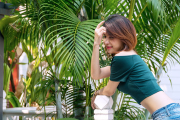 Young slim fit woman wearing hipster shirt and summer stylish jeans long in the garden. Teenagers girl wearing denim pants showing her beautiful fit body. Lifestyle and people concept