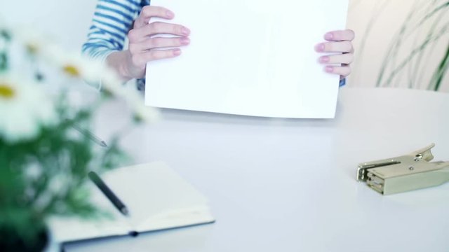 Woman signs documents, signs and stamps. fills data in graphs on paper. Draws the table. Records information. The woman is engaged in office work. A woman works at the offside table.
