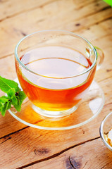 Cup with tea and mint on wooden table