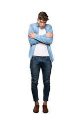 A full-length shot of a Handsome young man freezing over isolated white background