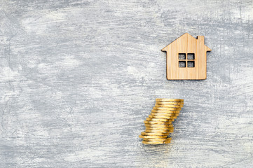 The house symbol is made of bamboo and yellow shiny coins on a scratched concrete background.