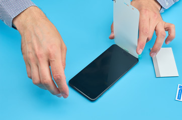 The man replacing the broken tempered glass screen protector for smartphone.