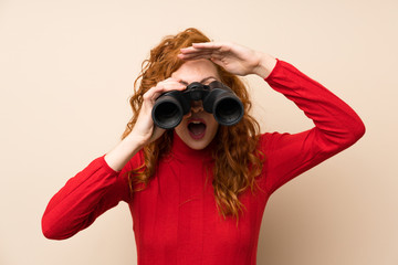 Redhead woman with turtleneck sweater with black binoculars