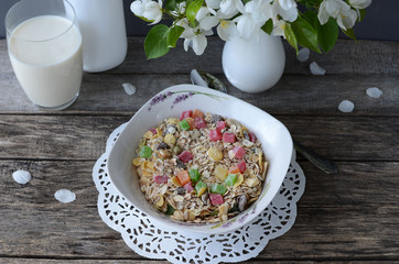 Breakfast: muesli with a glass of milk and a bouquet of blooming apple tree branches