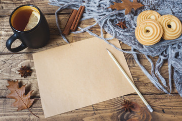 Autumn still life with cup of tea, cookies, sweater and leaves on wooden background. concept of cozy autumn, fall season Form for text.