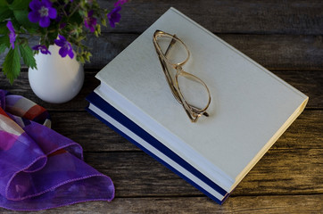 Books on the table with glasses. Evening reading.