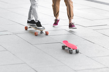 Fototapeta premium cropped view of man and woman riding on skateboards