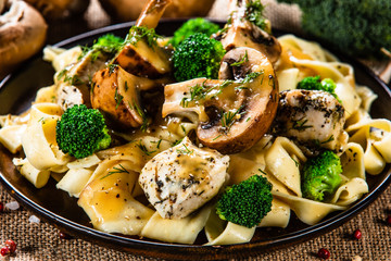 Pasta with chicken and champignon on wooden background