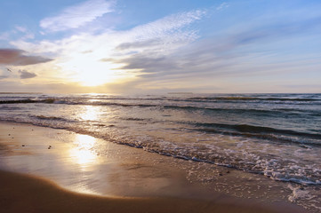 Sunset over the sea. Reflection of sunlight in the sea waves. The sky in the sunset rays.