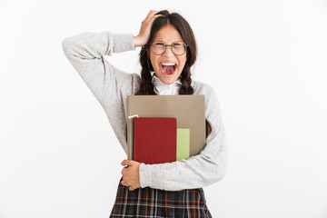 Photo closeup of nervous teenage girl wearing eyeglasses stressing and grabbing her head while holding studying books