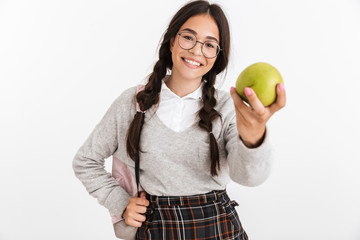Photo closeup of caucasian teenage girl wearing eyeglasses and backpack eating green apple