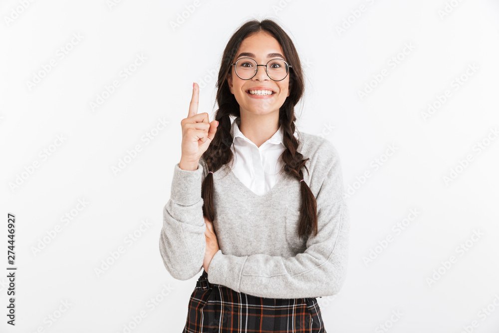 Canvas Prints Photo closeup of excited teenage girl wearing eyeglasses smiling and pointing finger upward at copyspace