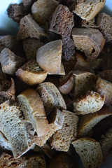 Fresh pieces of gray bread on a dark protvino for making crispy homemade crackers. Diet, proper nutrition, delicious food for life.