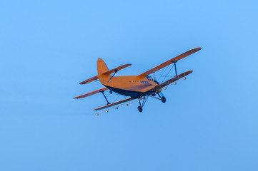 Fototapeta na wymiar View on an old plane flying againtst the blue sky