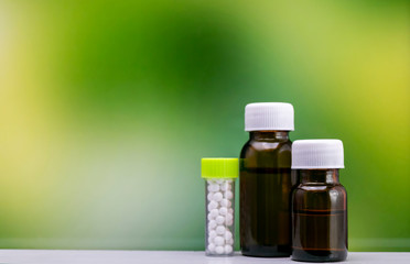 Homeopathy – Close view of homeopathy  medicine bottles on mix green yellow background