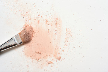 Pink make up spilled over white surface with make up brush covered in powder - obrazy, fototapety, plakaty