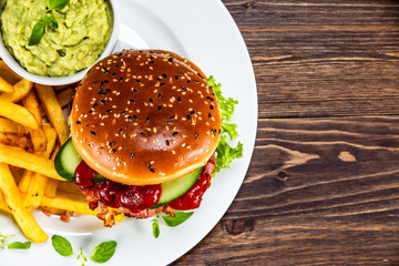 Tasty burger with chips served white plate