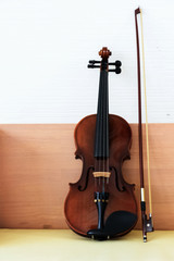 Fototapeta na wymiar The classic violin and bow put on wooden desk,show detail of acoustic instrument