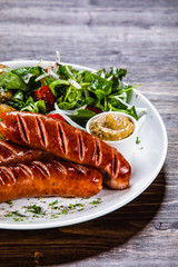 Grilled sausages, baked potatoes and vegetables