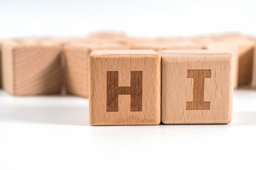 word HI on wood cube dices on white background.