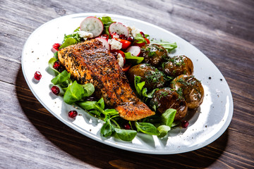 Grilled salmon, baked potatoes and vegetable salad